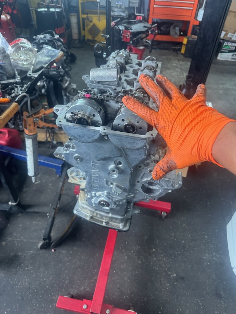 Detailed close-up of a mechanic installing a high-performance brake rotor and red caliper on a vehicle